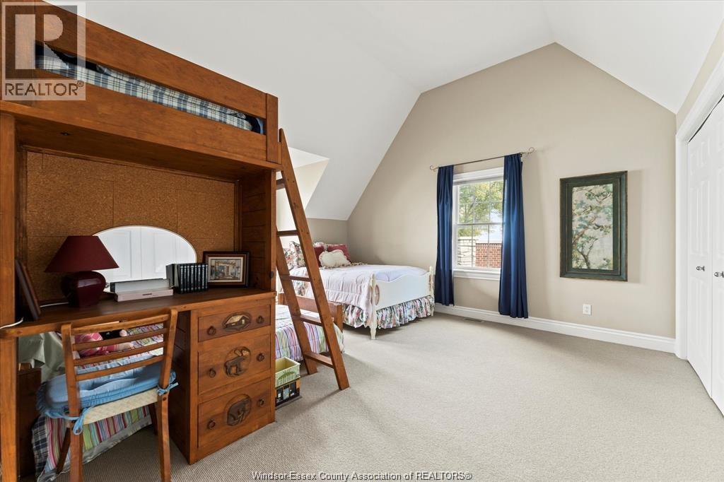 A bedroom with a bunk bed and a window with blue curtains.