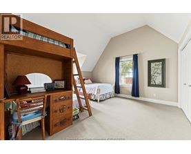 A bedroom with a bunk bed and a window with blue curtains.