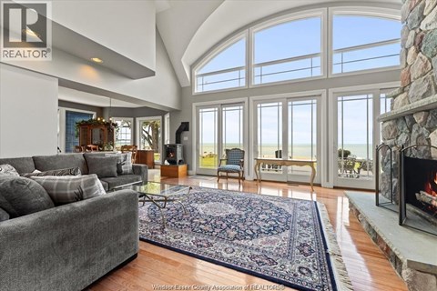 A living room with a grey couch and a fireplace.