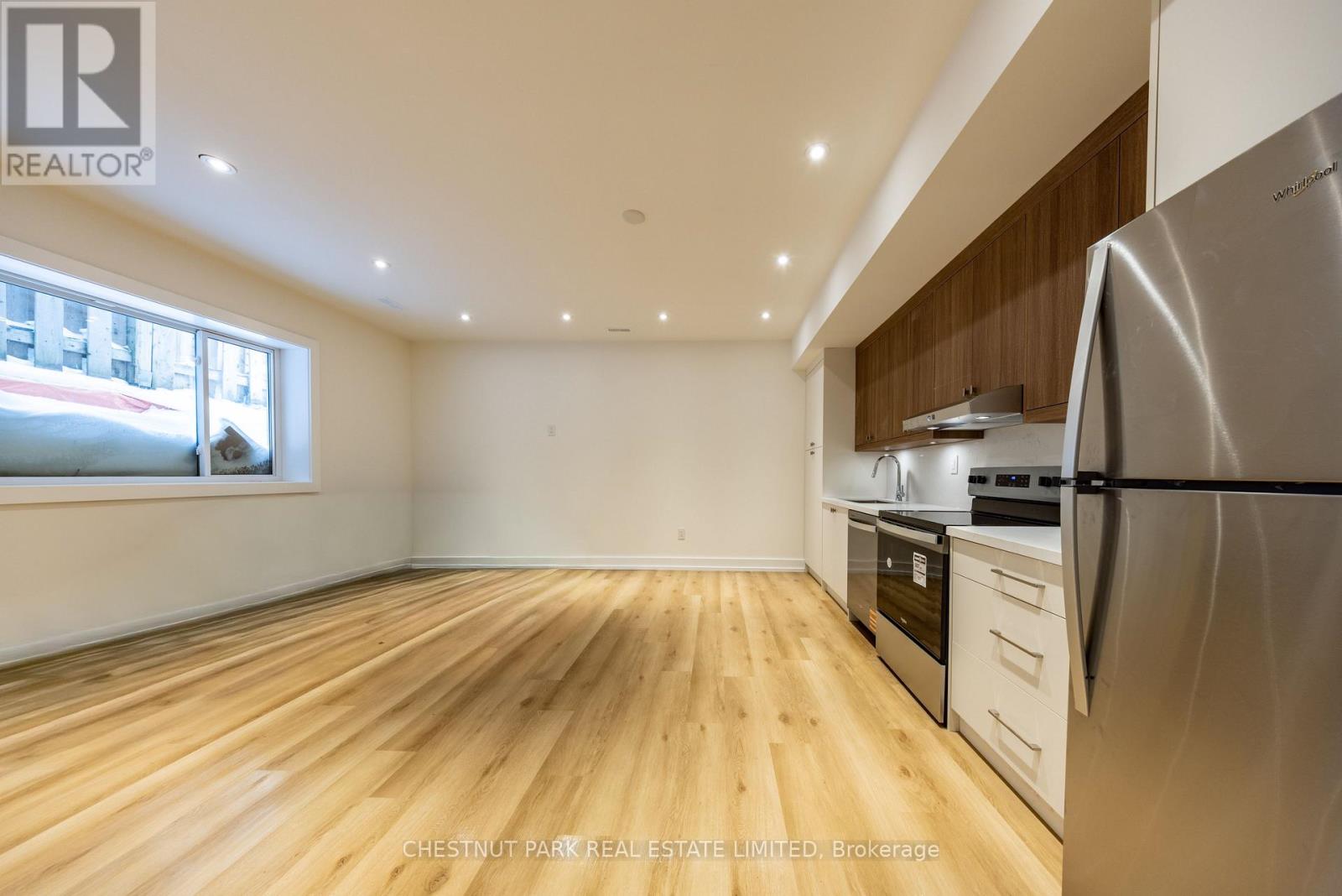 A kitchen with wooden floors and stainless steel appliances.