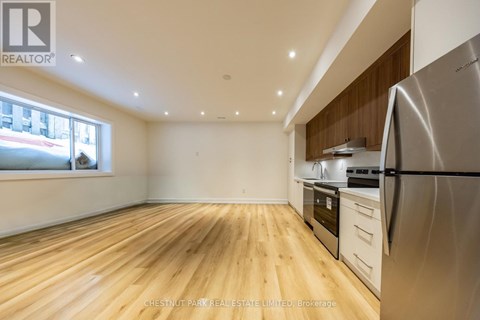A kitchen with wooden floors and stainless steel appliances.