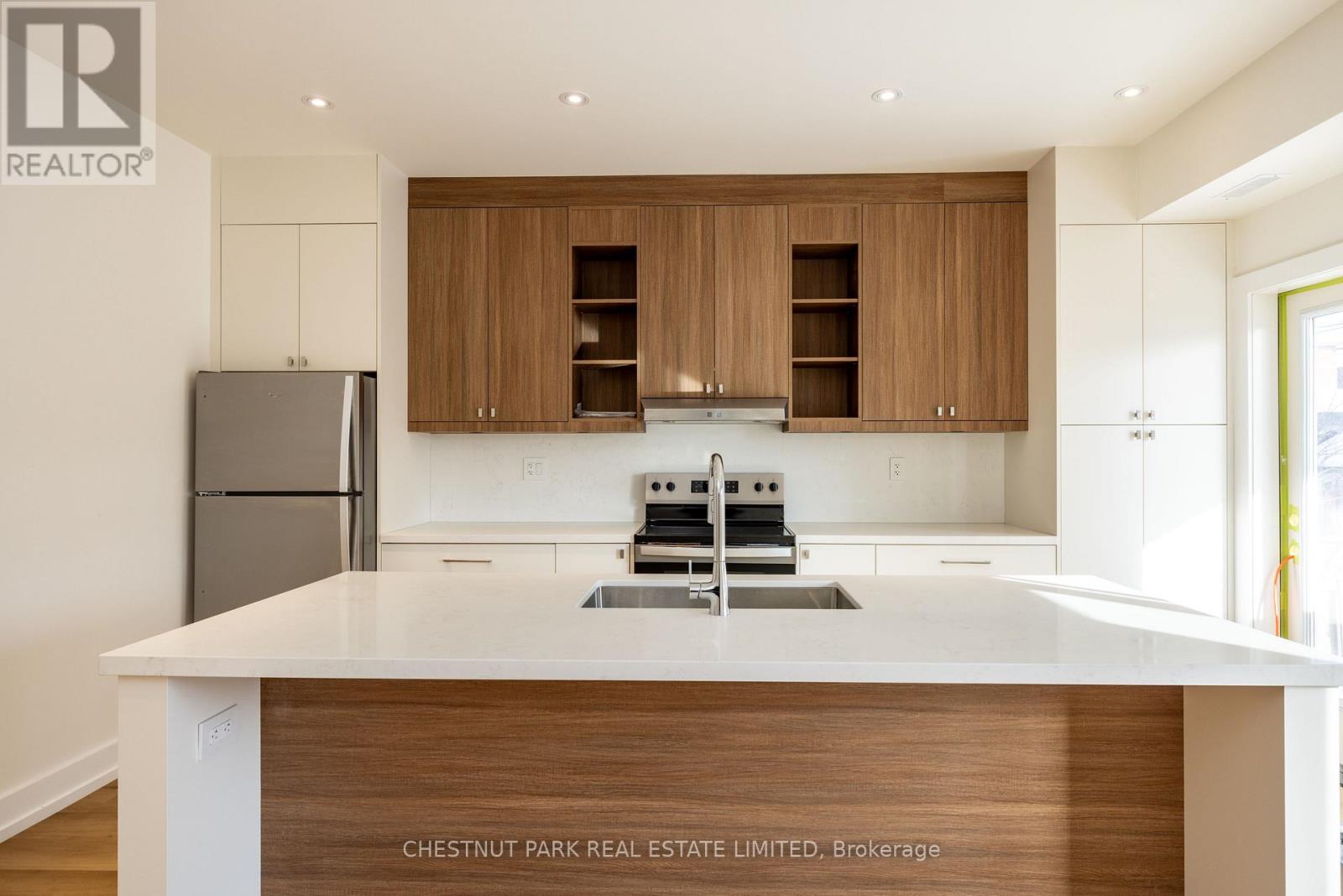 A modern kitchen with wooden cabinets and a white countertop.