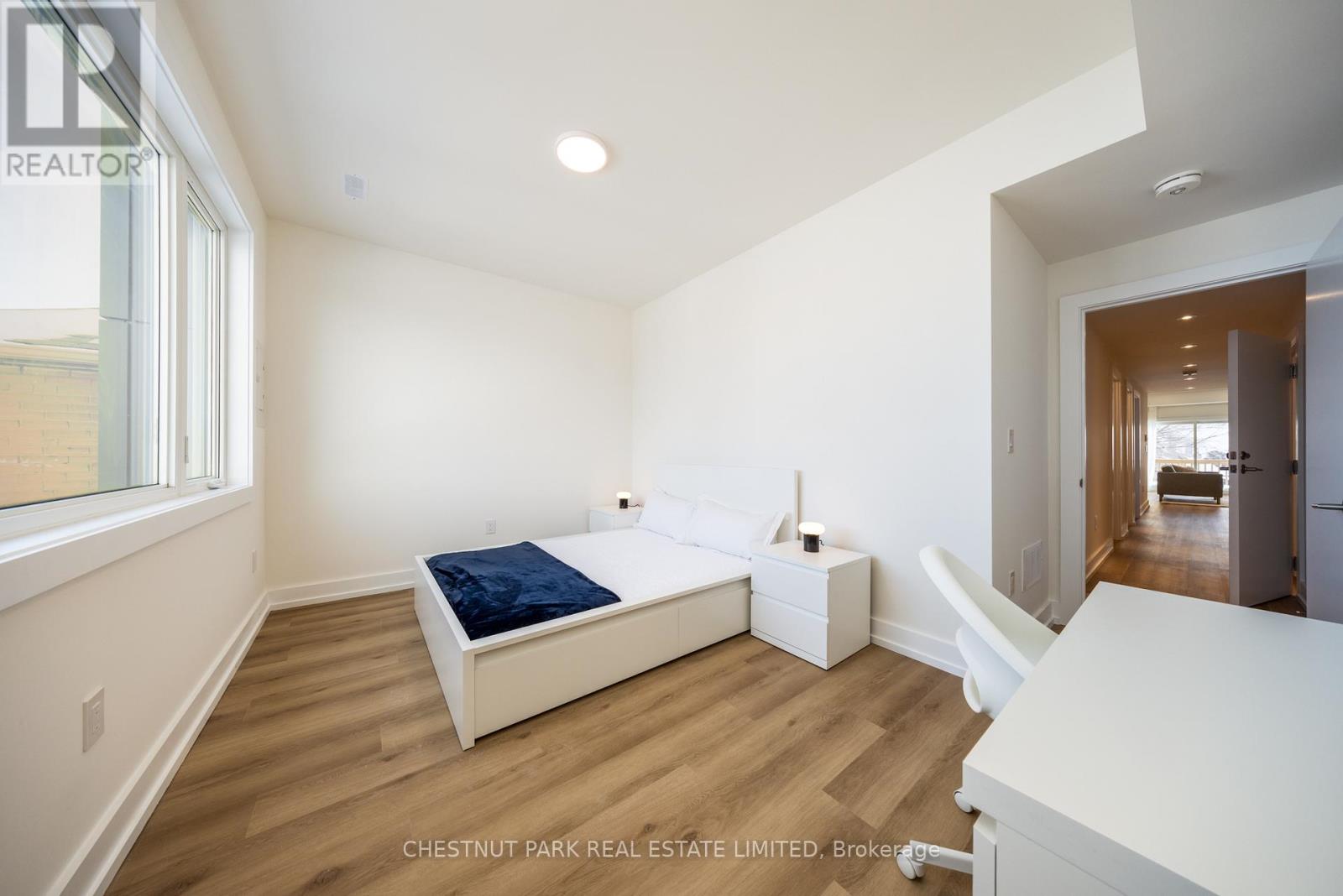 A bedroom with a bed, nightstand, and chair.