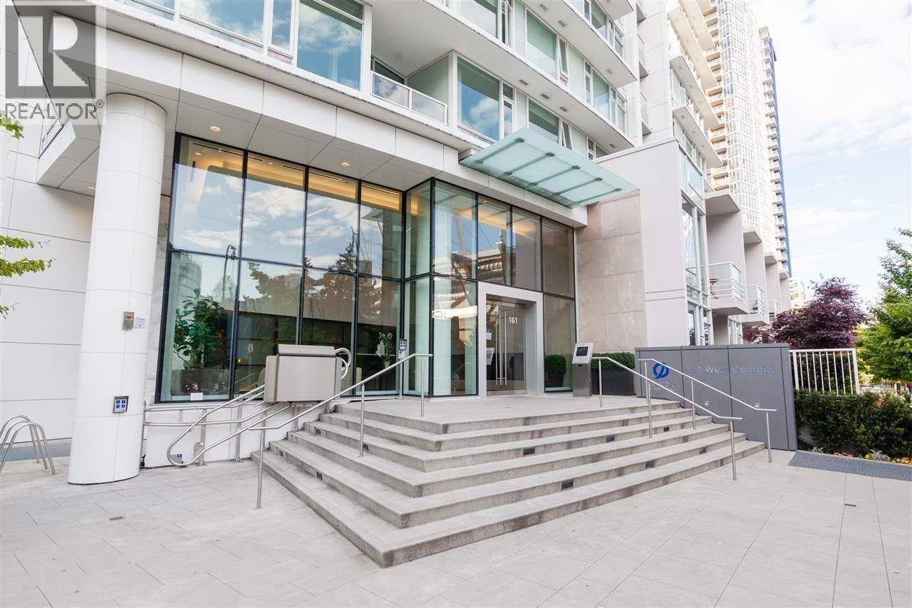 A modern building with a glass entrance and steps leading up to it.