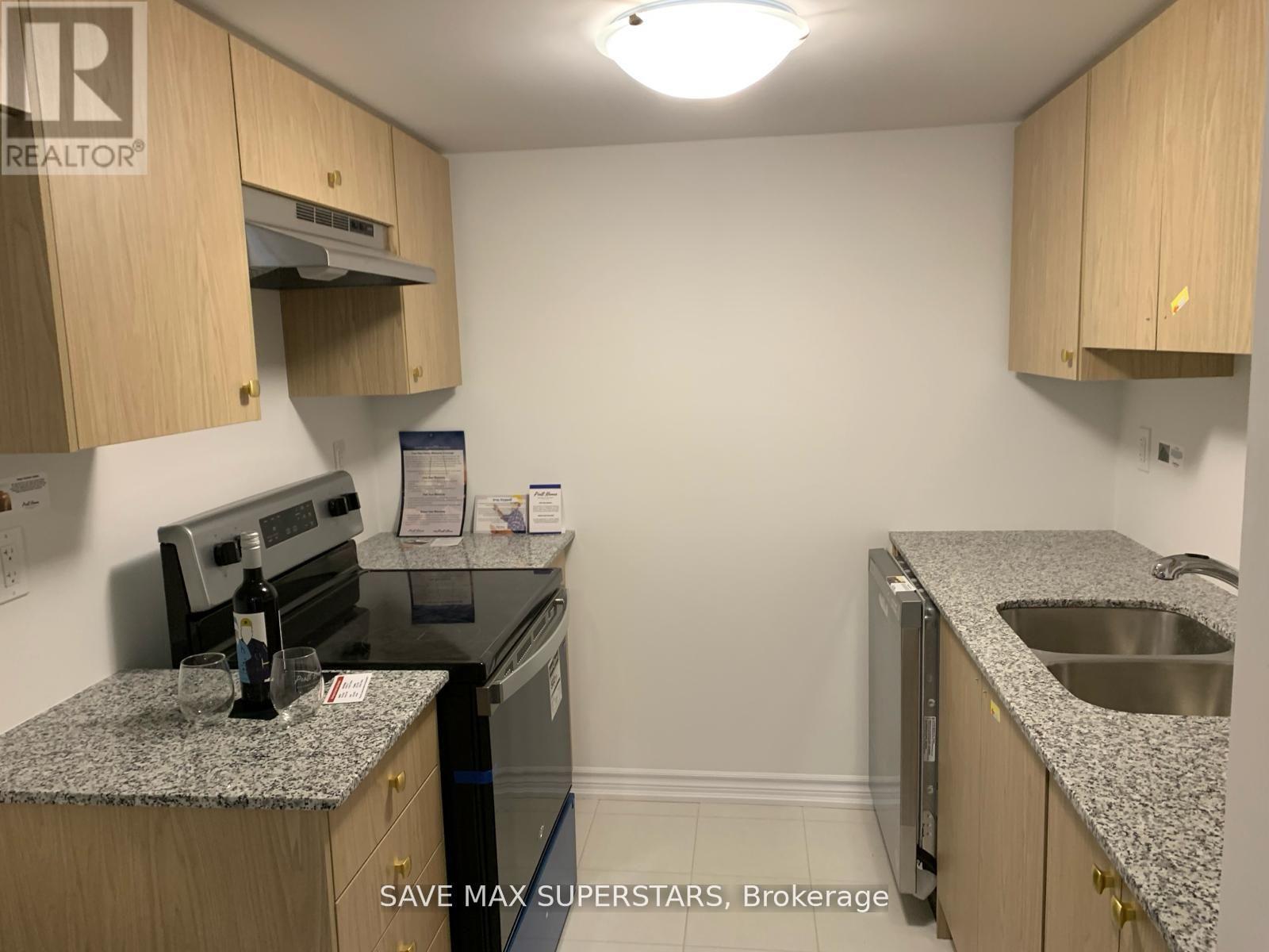A kitchen with granite countertops and wooden cabinets.
