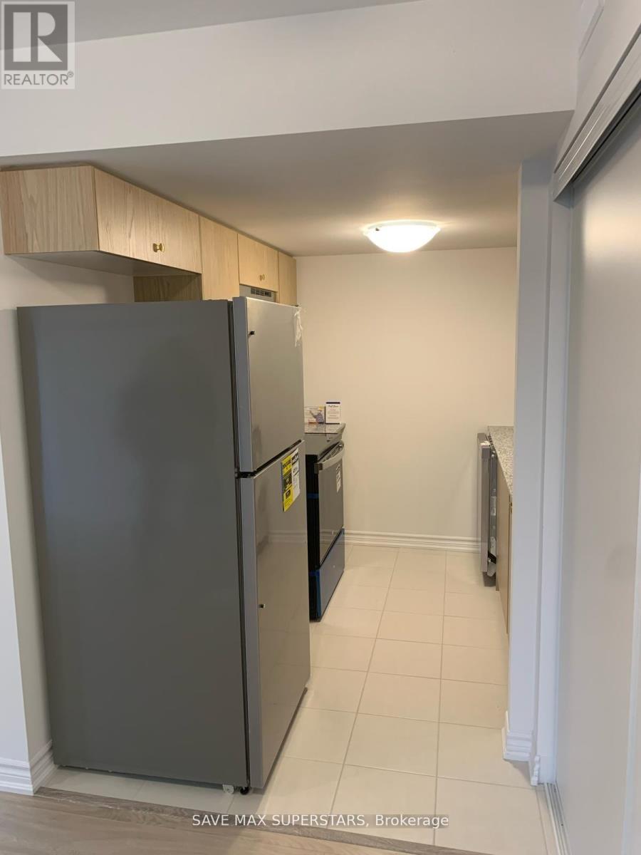 A kitchen with a refrigerator and a brokerage sign.