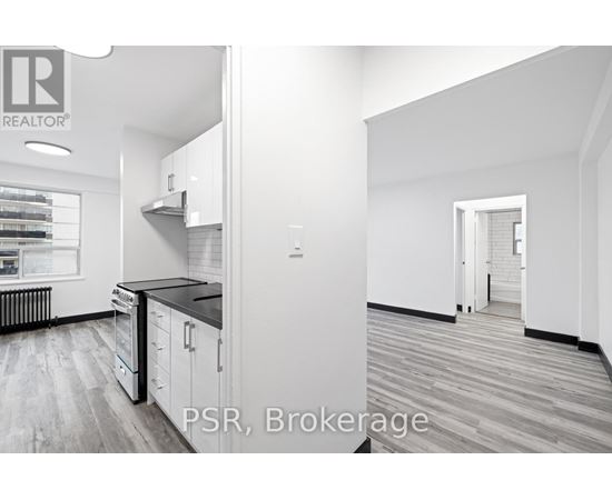 A modern kitchen with white cabinets and a black countertop.