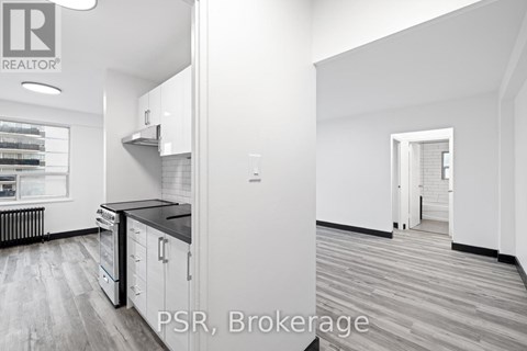 A modern kitchen with white cabinets and a black countertop.