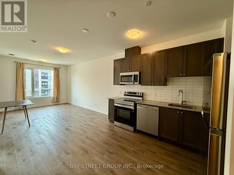 A kitchen with wooden cabinets and a refrigerator.