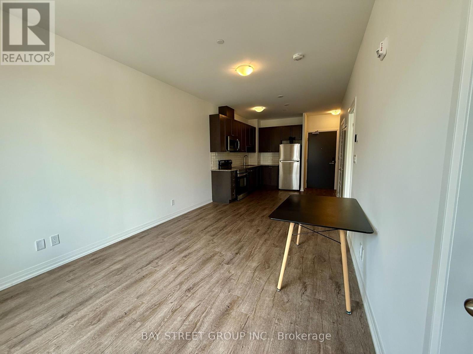 A room with a table and a kitchen area in the background.