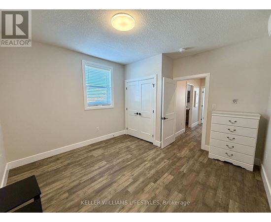 A bedroom with a wooden floor and a white dresser.