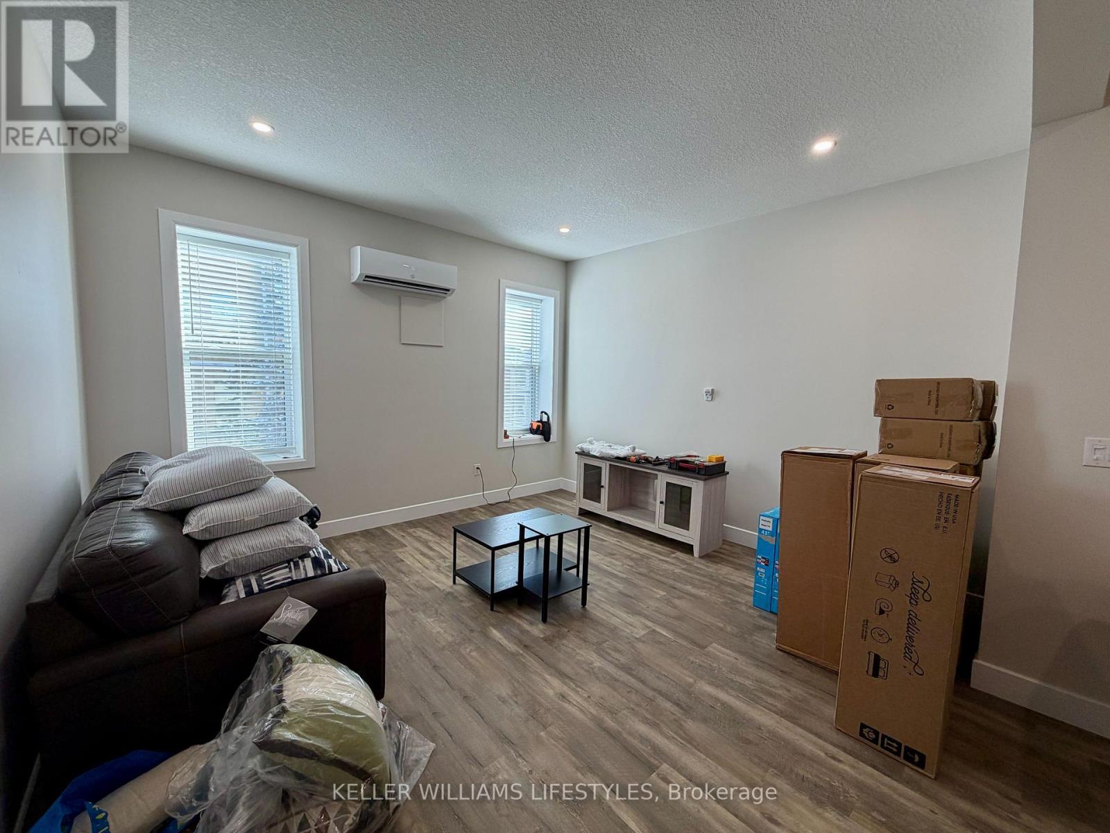 A living room with a couch, a coffee table, and boxes on the floor.
