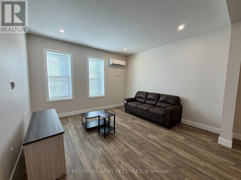 A living room with a black leather couch and a wooden coffee table.
