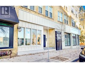 A building with a realtor sign on the corner.