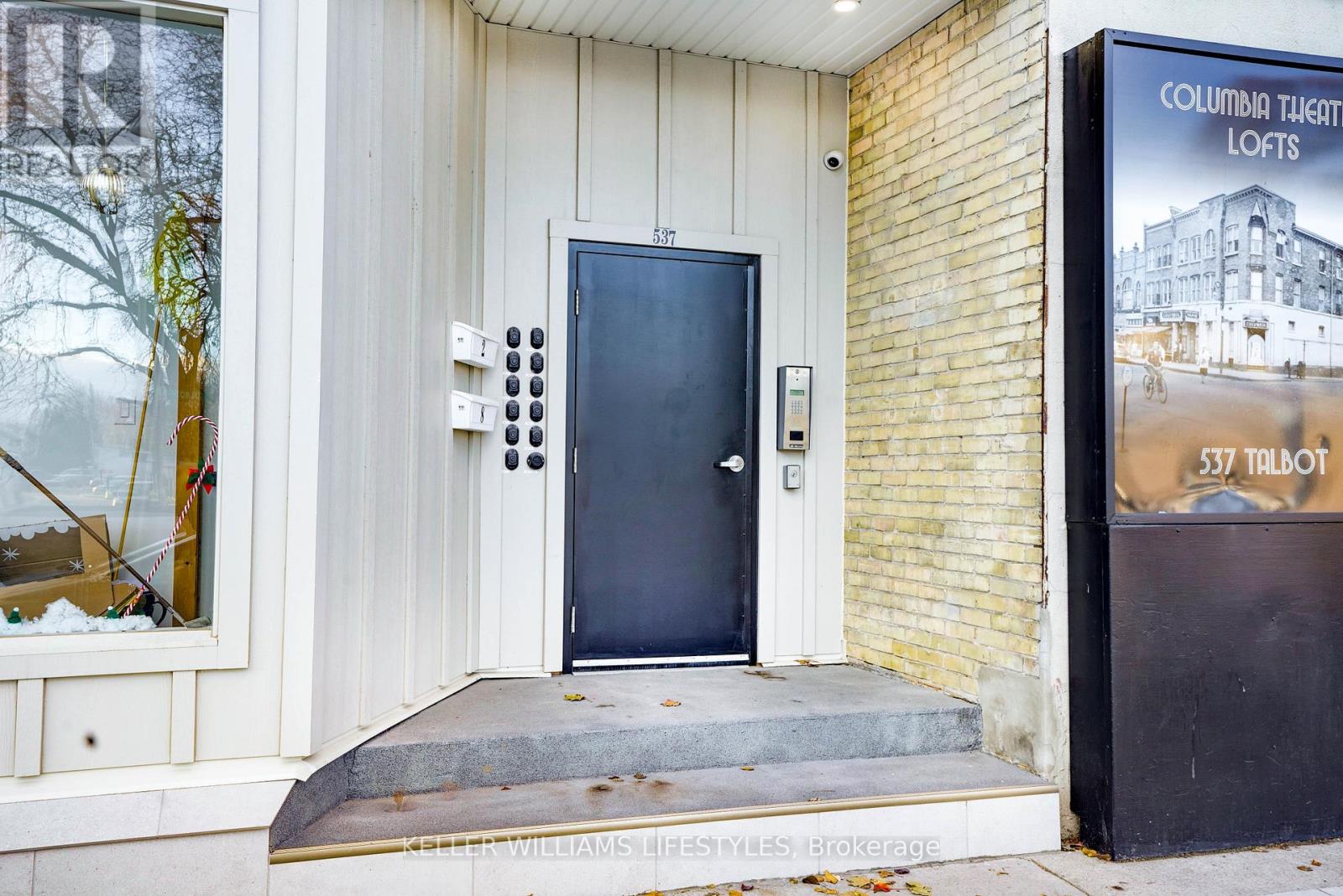 A door with a black handle and a sign on the wall.