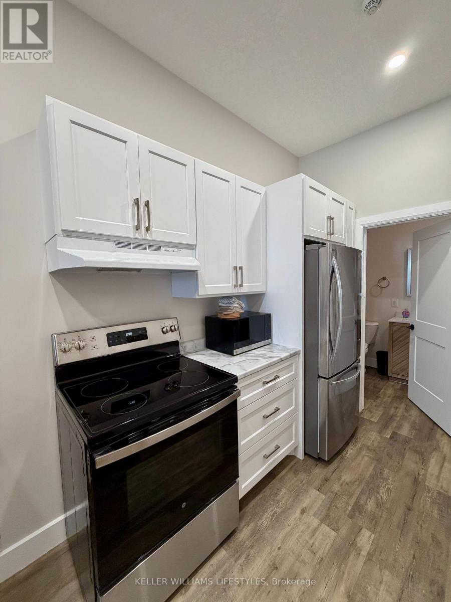 A kitchen with white cabinets and a black stove top oven.
