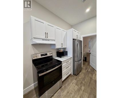 A kitchen with white cabinets and a black stove top oven.