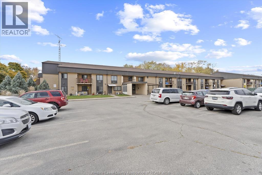 A parking lot with cars and a building in the background.