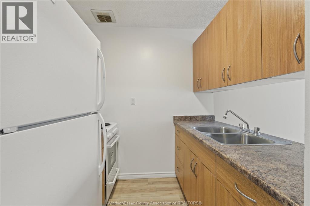 A kitchen with a white refrigerator and wooden cabinets.