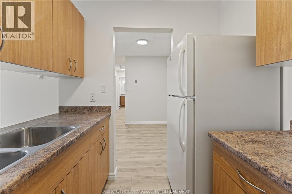 A kitchen with wooden cabinets and a white refrigerator.