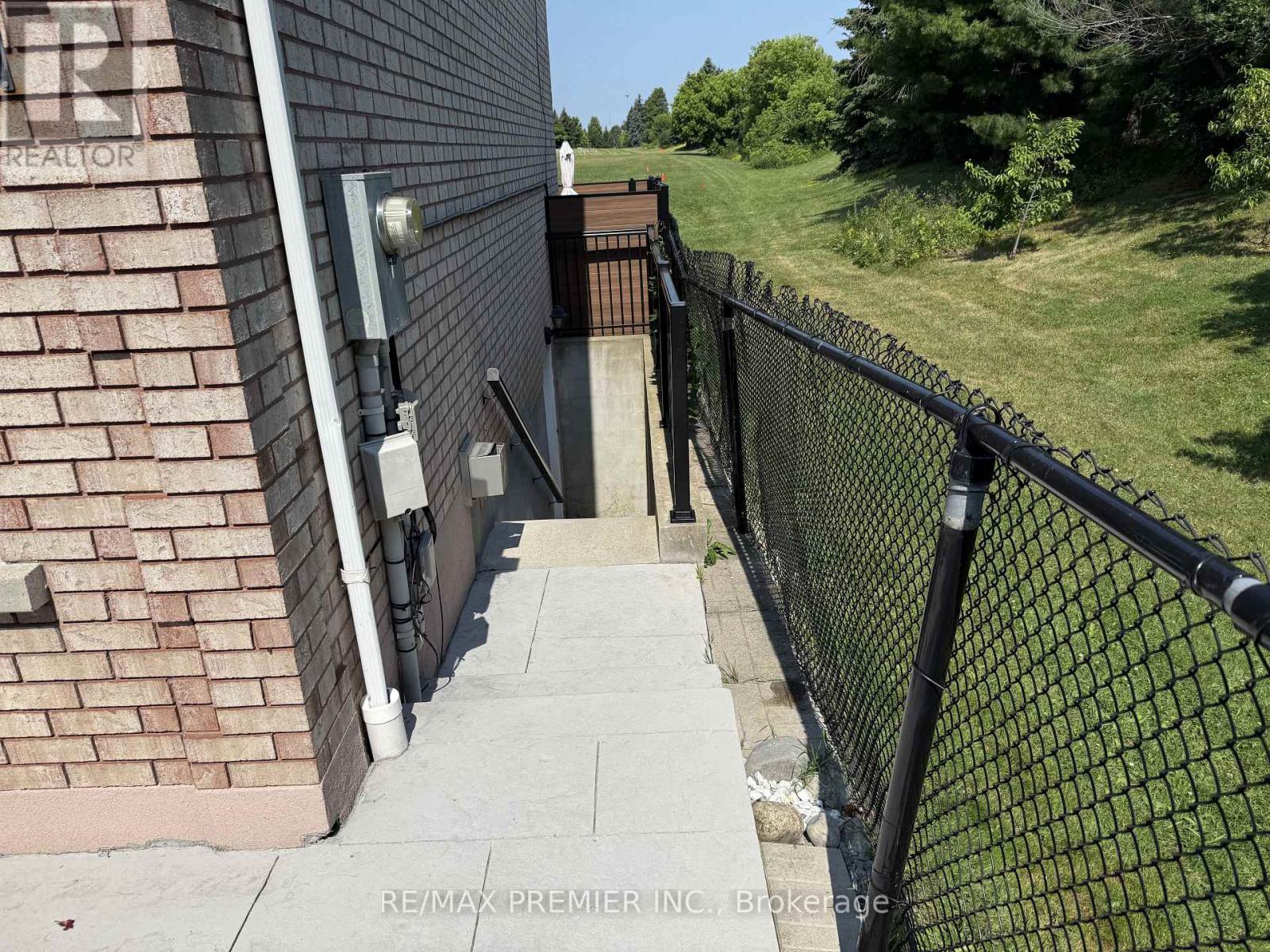 A black metal fence runs along the side of a brick building.
