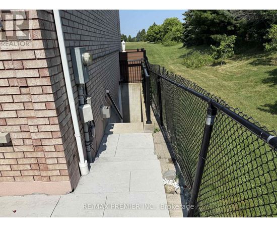 A black metal fence runs along the side of a brick building.