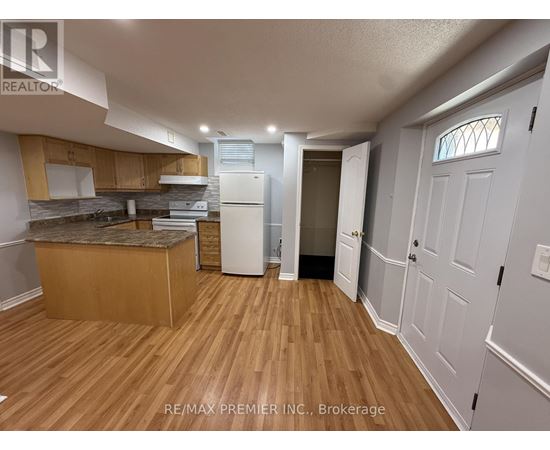 A kitchen with wooden floors and white appliances.