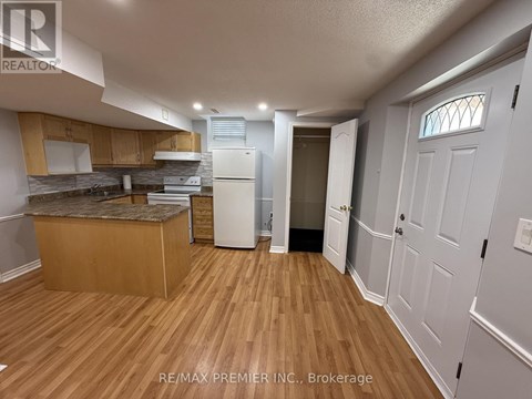 A kitchen with wooden floors and white appliances.