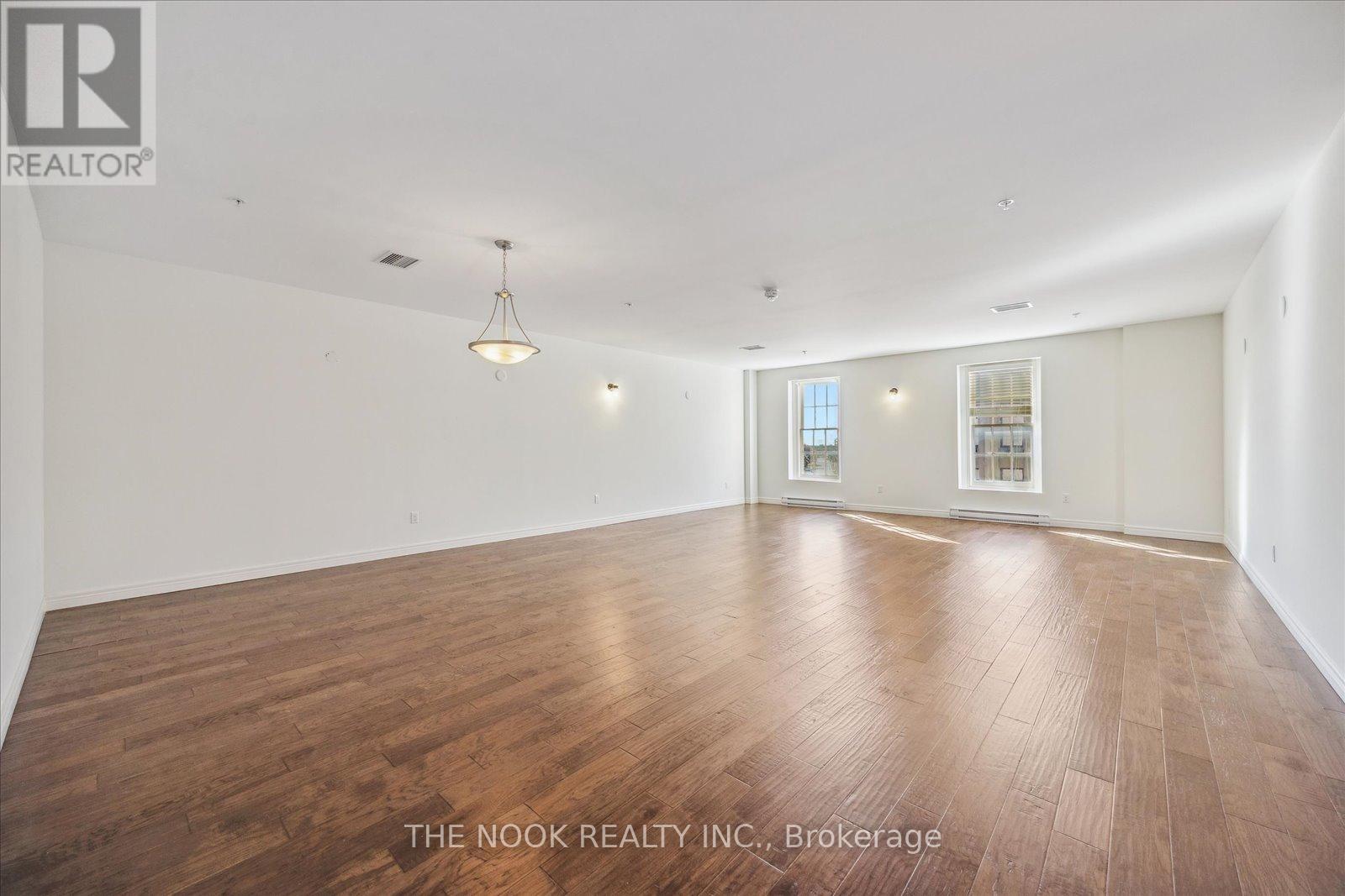 A large empty room with wooden floors and white walls.