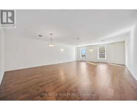 A large empty room with wooden floors and white walls.