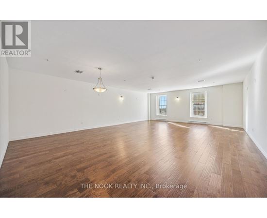 A large empty room with wooden floors and white walls.