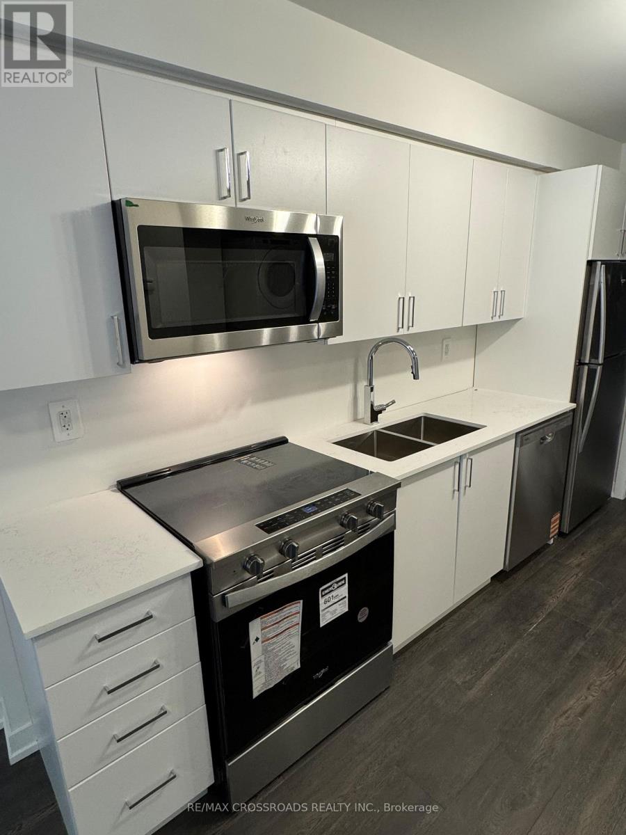 A modern kitchen with white cabinets and stainless steel appliances.
