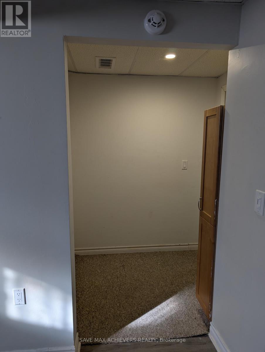 A room with a door and a light switch on the wall.