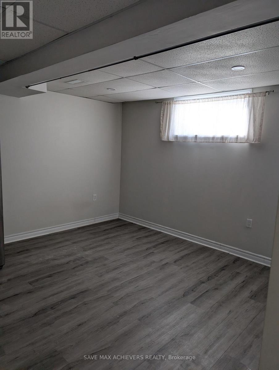 A room with wooden flooring and a window with curtains.