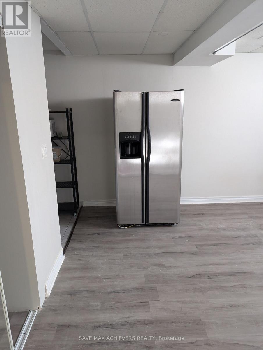 A stainless steel refrigerator in a room with wooden flooring.