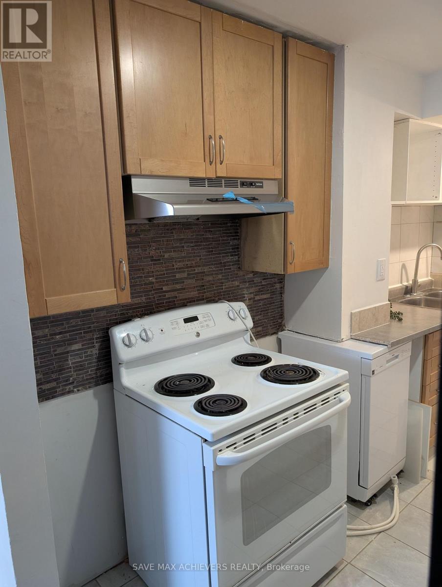 A white stove and dishwasher in a kitchen with wooden cabinets.