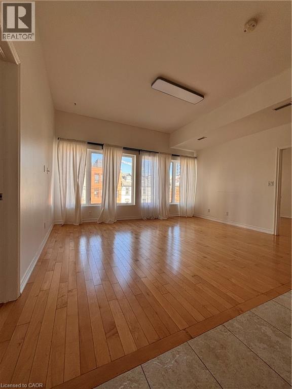 A room with a window overlooking a street with apartment buildings.