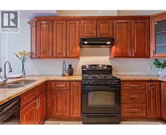 A kitchen with wooden cabinets and a black stove top oven.