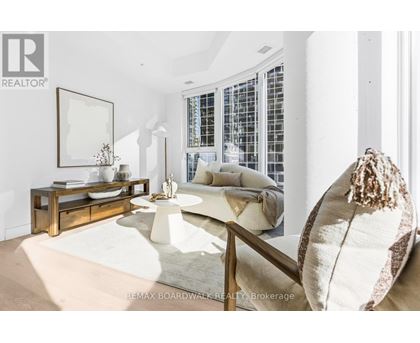 A living room with a white couch and a wooden coffee table.