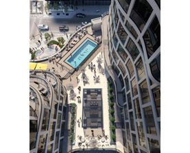 A modern building with a pool in the middle of a plaza.