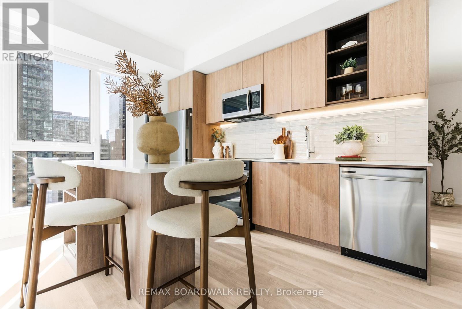 A kitchen with a white counter top and wooden bar stools.