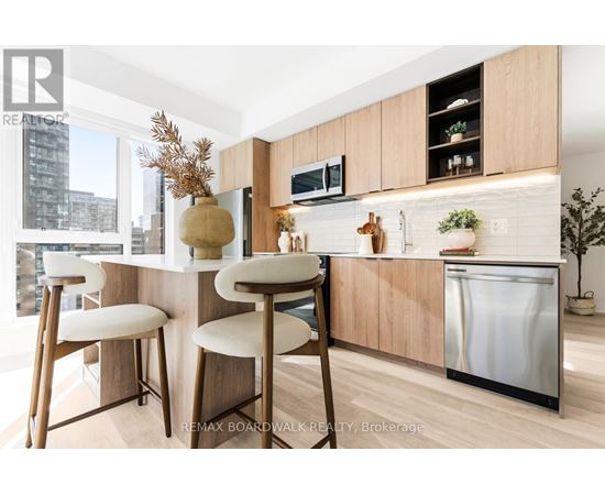A kitchen with a white counter top and wooden bar stools.