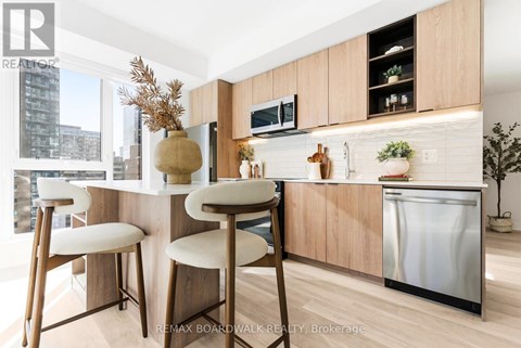 A kitchen with a white counter top and wooden bar stools.