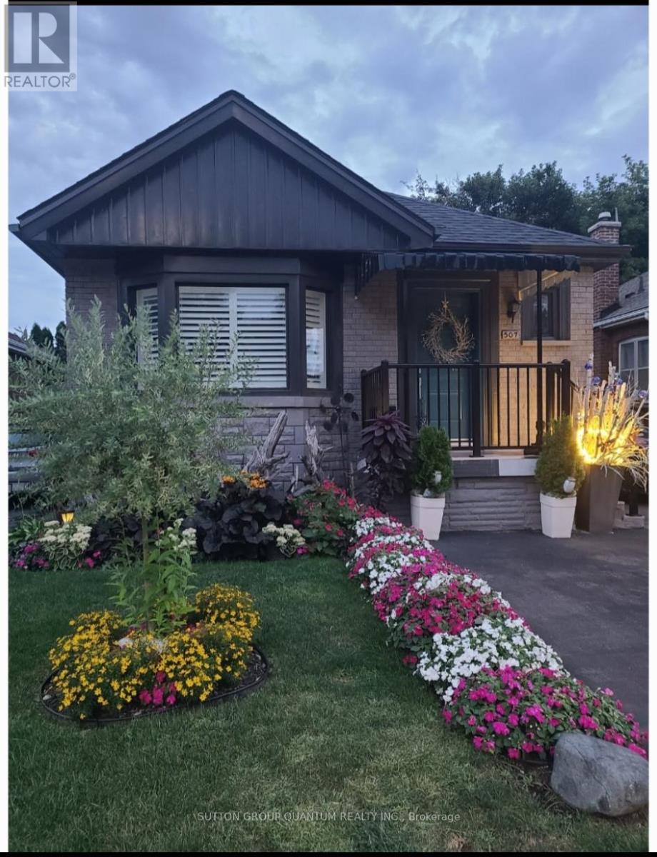 A house with a flower bed in front of it.