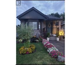 A house with a flower bed in front of it.