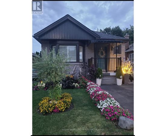 A house with a flower bed in front of it.