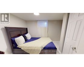 A bedroom with a bed, pillows, and a window with curtains.