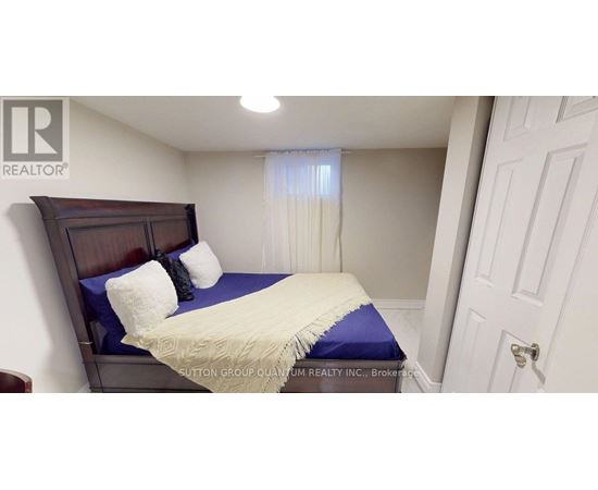 A bedroom with a bed, pillows, and a window with curtains.