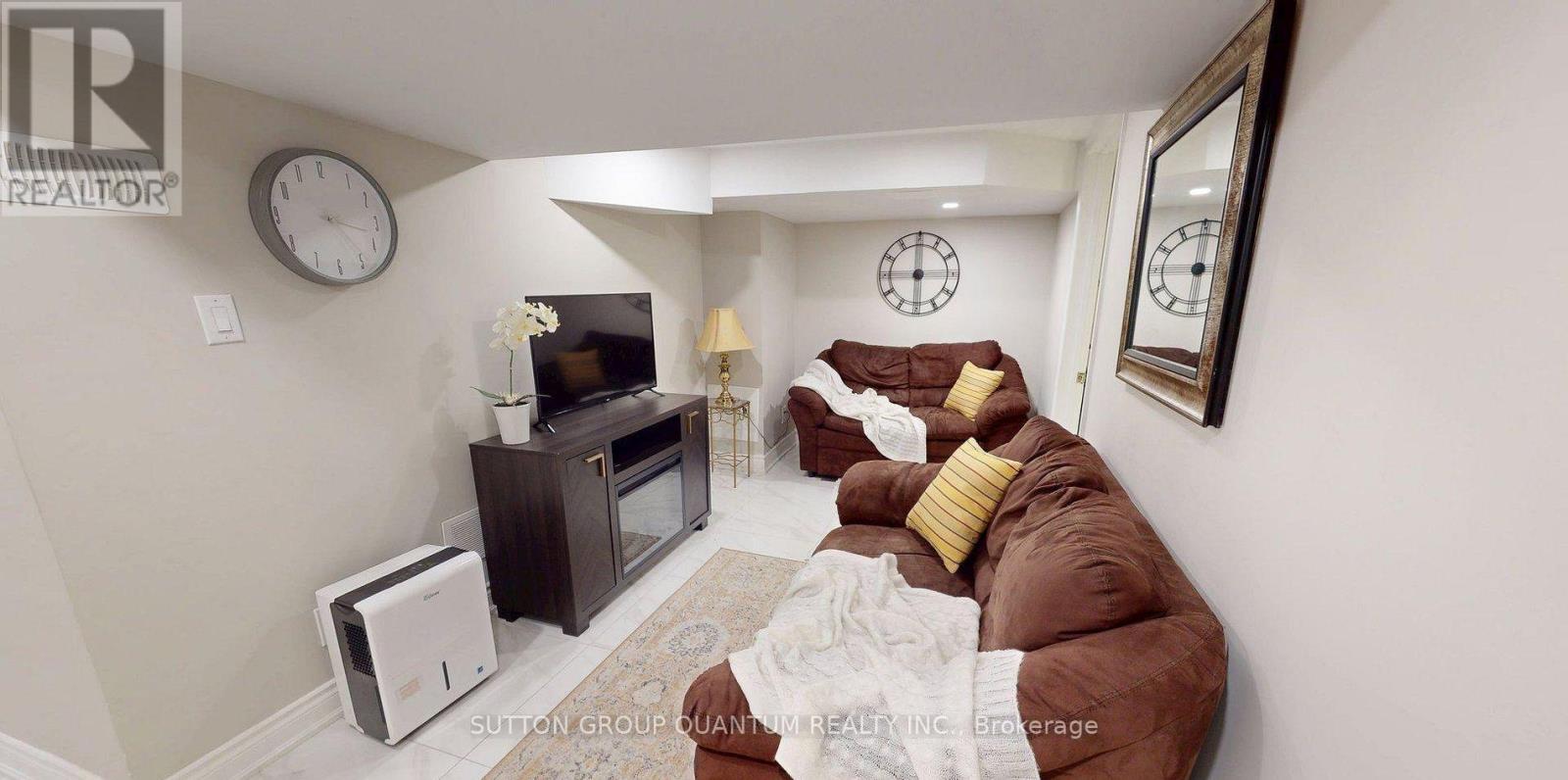 A living room with a brown couch and a flat screen TV.