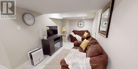 A living room with a brown couch and a flat screen TV.